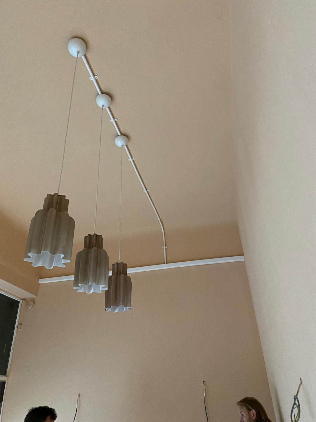 Three modern pendant lights installed over a kitchen island